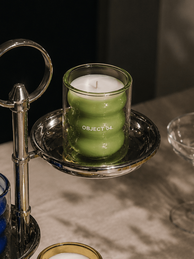 Mint and basil scented soy candle in green glass jar on a metal tray