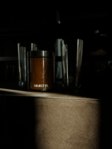 Amber glass jar scented candle with black label band, “OBJECT 01.” on front