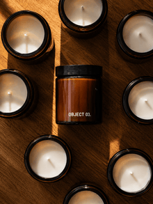 Small glass candles with black rims and flames, plus one amber candle in tin